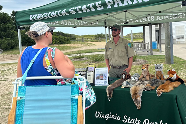 Ranger at a booth talking with a visitor